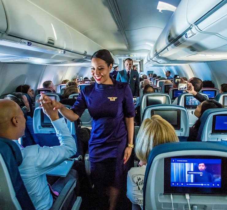 a woman standing in an airplane with people around