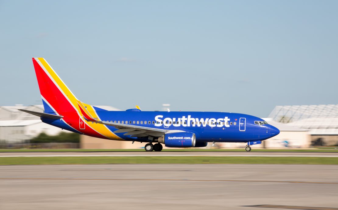 a blue and red airplane on a runway