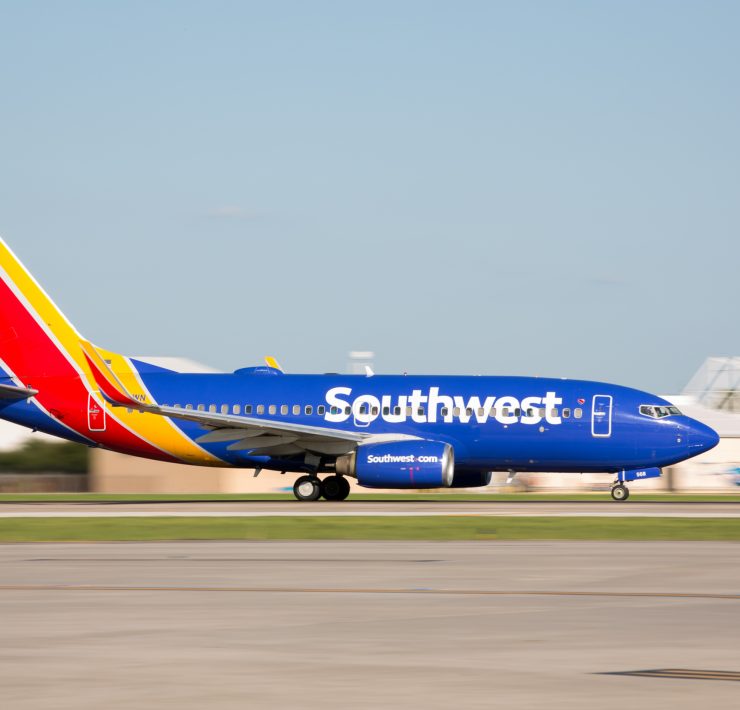 a blue and red airplane on a runway