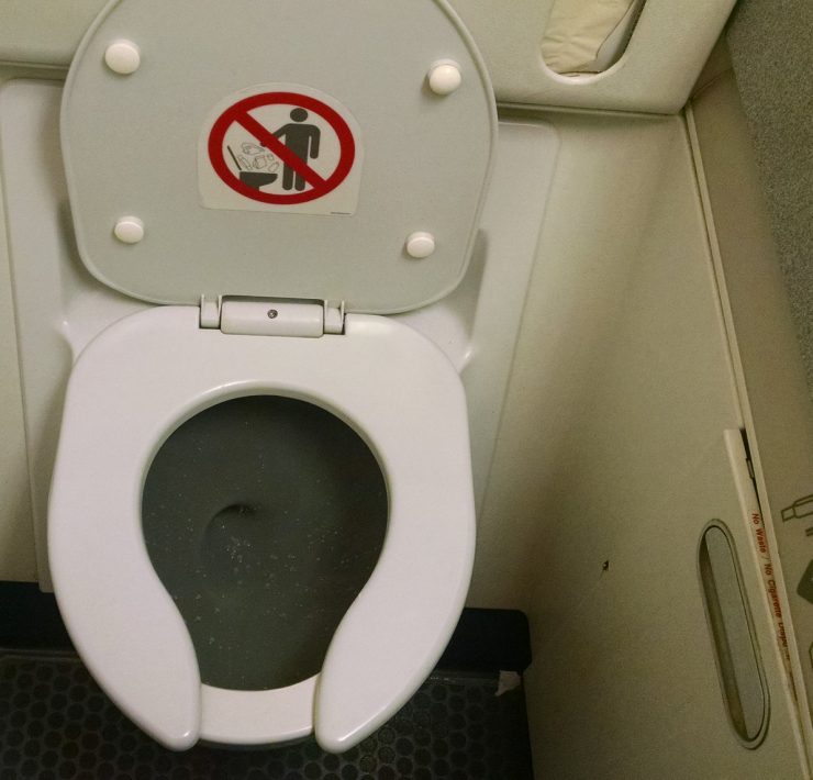 a toilet with a sign on the lid