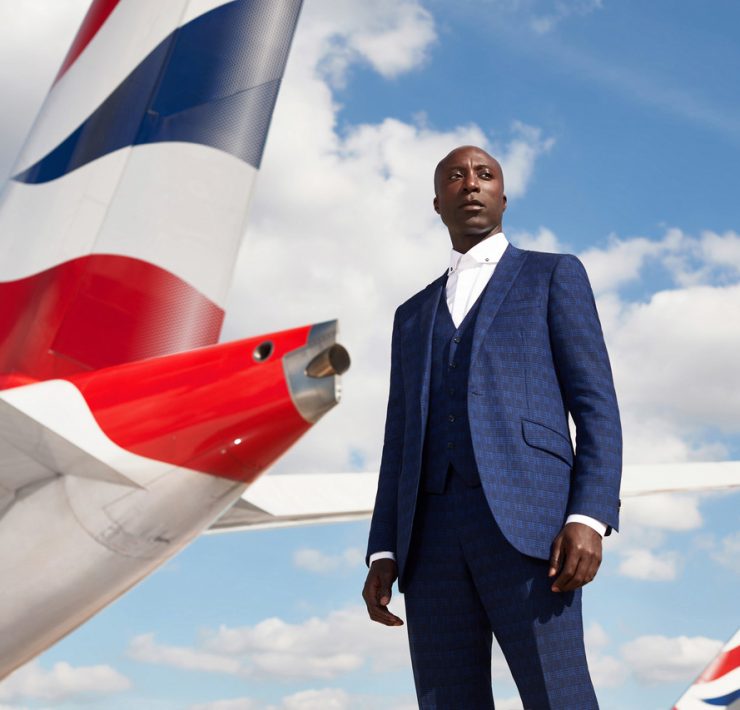 a man in a suit standing next to a plane