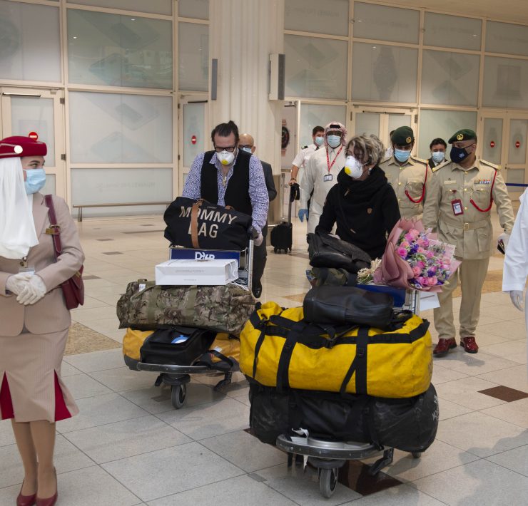 a group of people wearing face masks and standing in a hallway