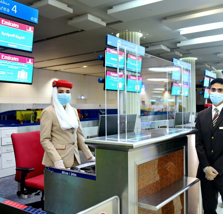 a man and woman wearing face masks at a check-in counter