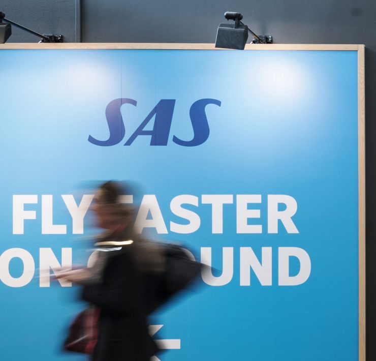 a blurry image of a woman walking in front of a large sign