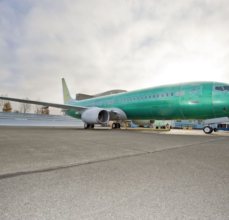 a green airplane on a tarmac