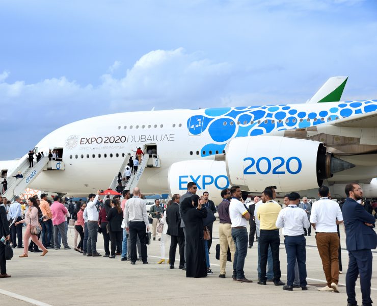 a group of people standing in front of an airplane