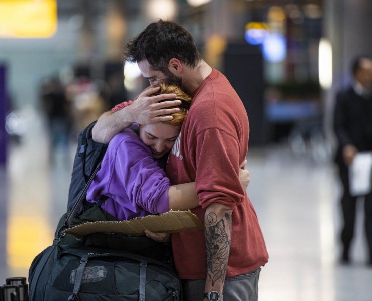 a man and woman hugging in an airport