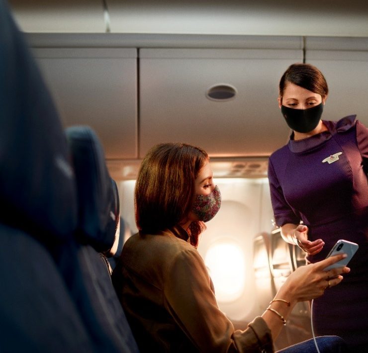 a woman wearing face masks and standing next to a woman wearing a mask