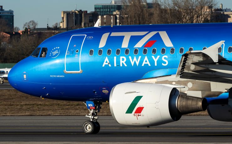 a blue airplane on a runway