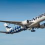 a white and blue airplane flying in the sky