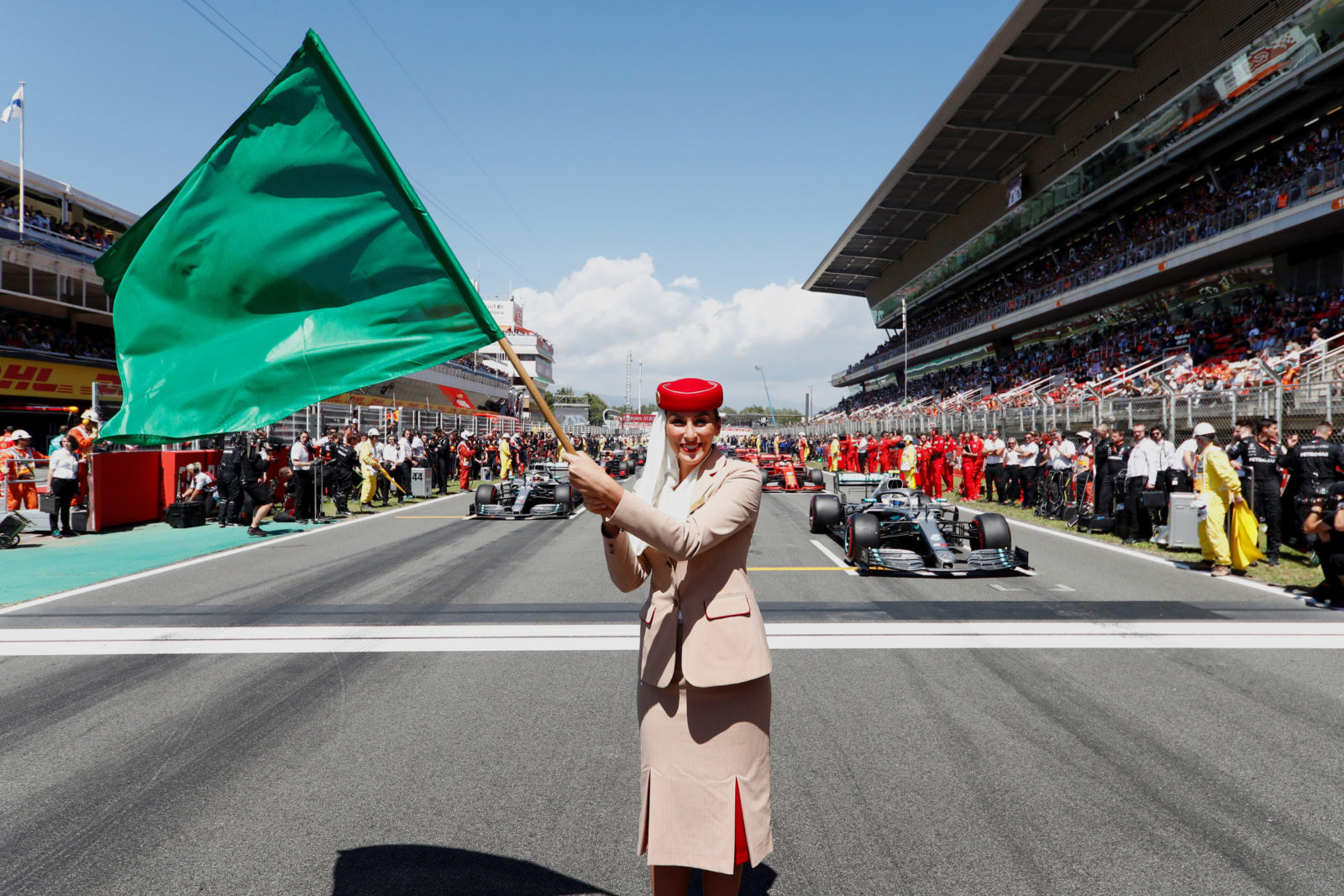 a woman holding a green flag in front of a crowd of people