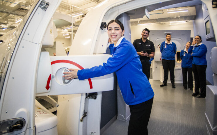 a woman in a blue jacket holding a machine