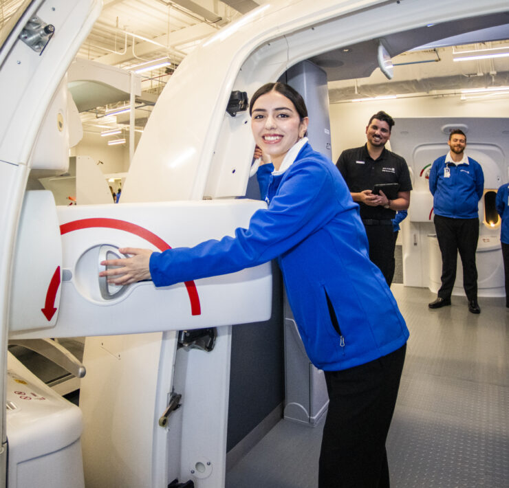 a woman in a blue jacket holding a machine