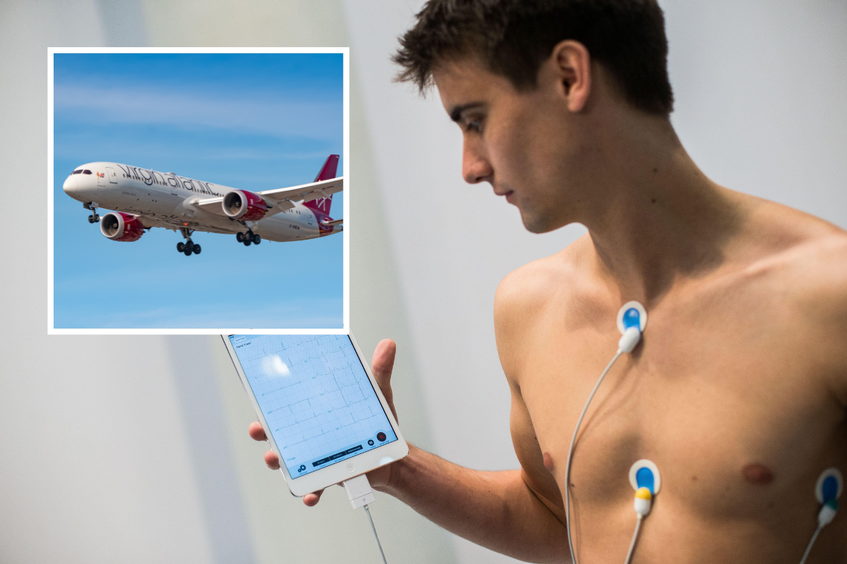 a man holding a device with an airplane in the background
