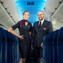 a man and woman standing in an airplane