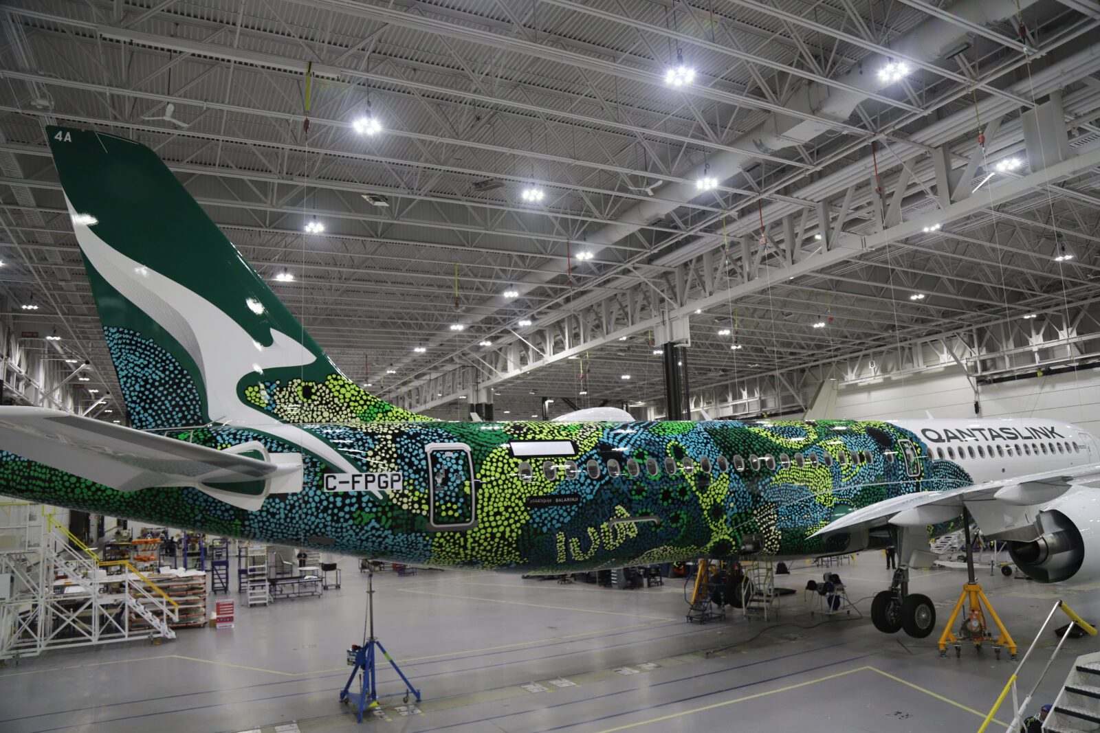 a green and white airplane in a hangar
