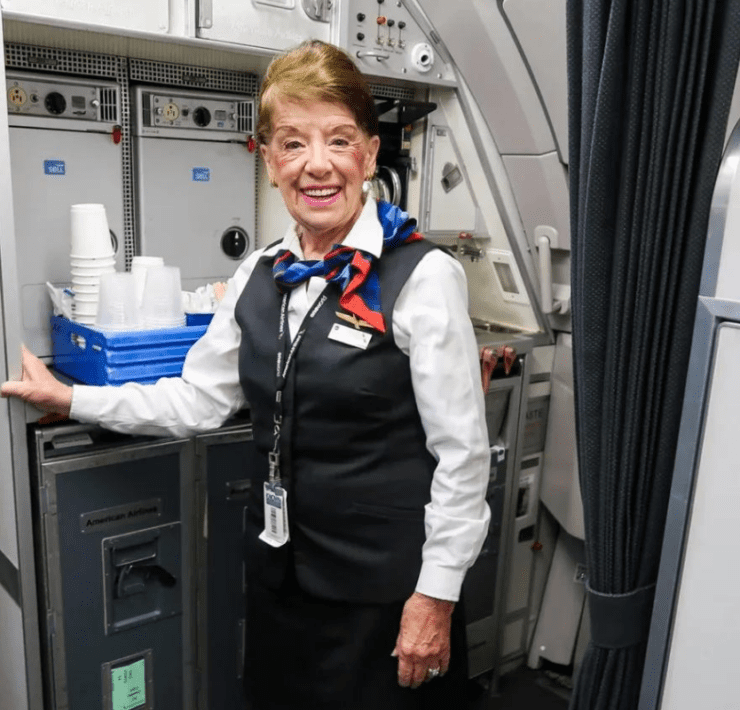 a woman in a uniform standing in a room with a door open