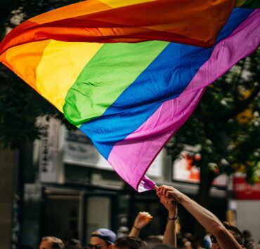 a group of people holding up a rainbow flag