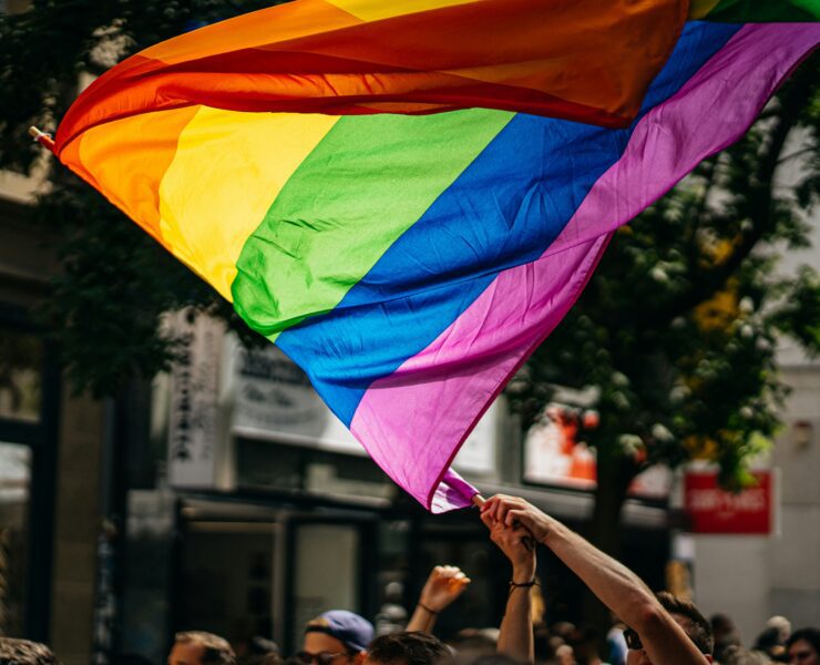 a group of people holding up a rainbow flag