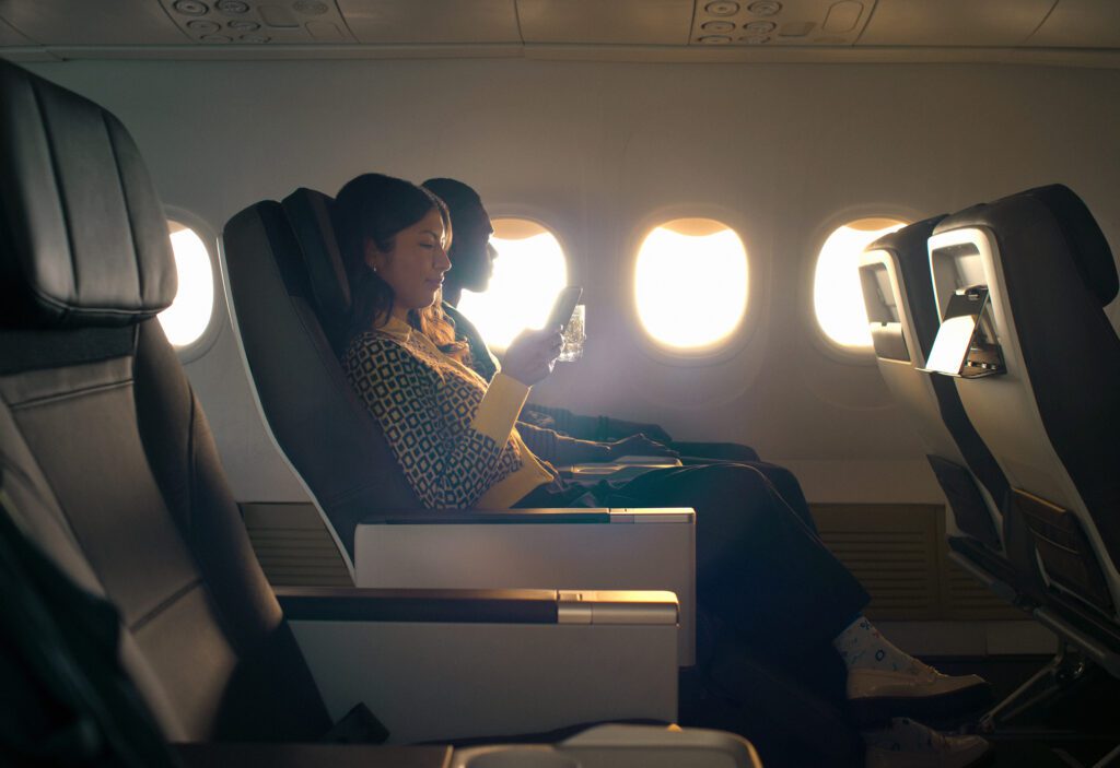 a woman sitting in a plane with a phone