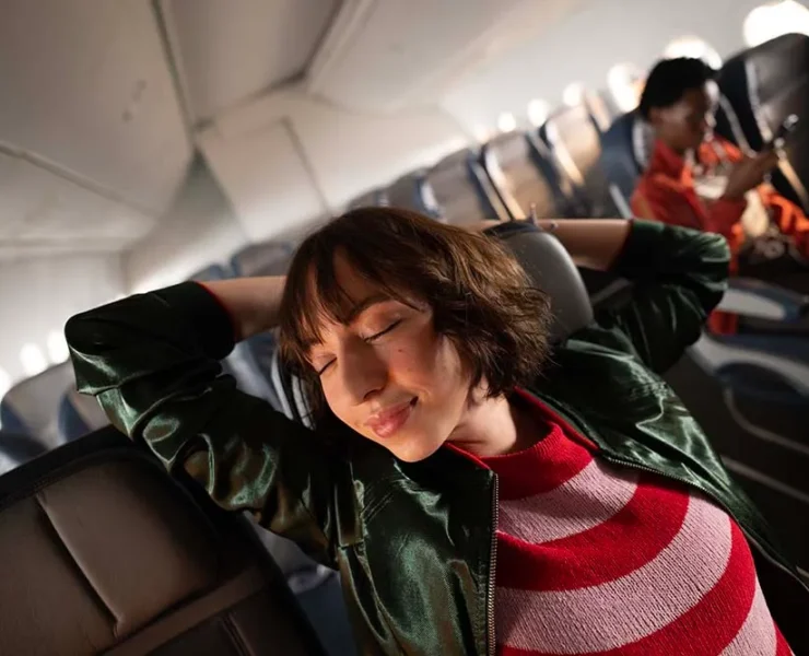 a woman sleeping on an airplane