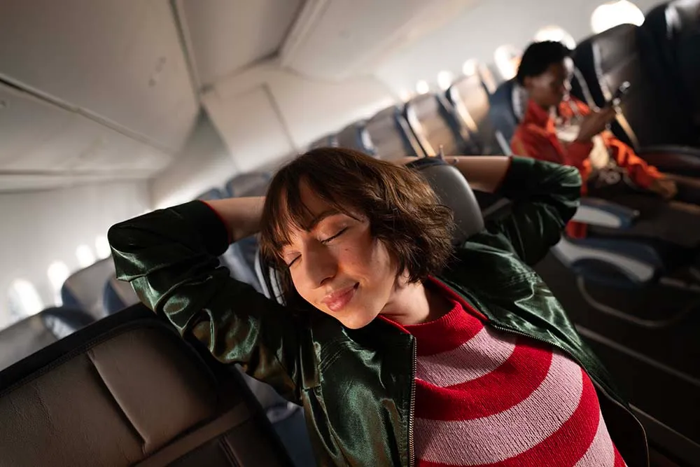 a woman sleeping on an airplane