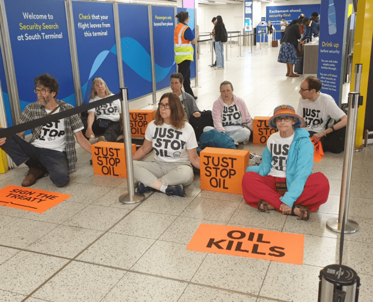 a group of people sitting on the floor with signs