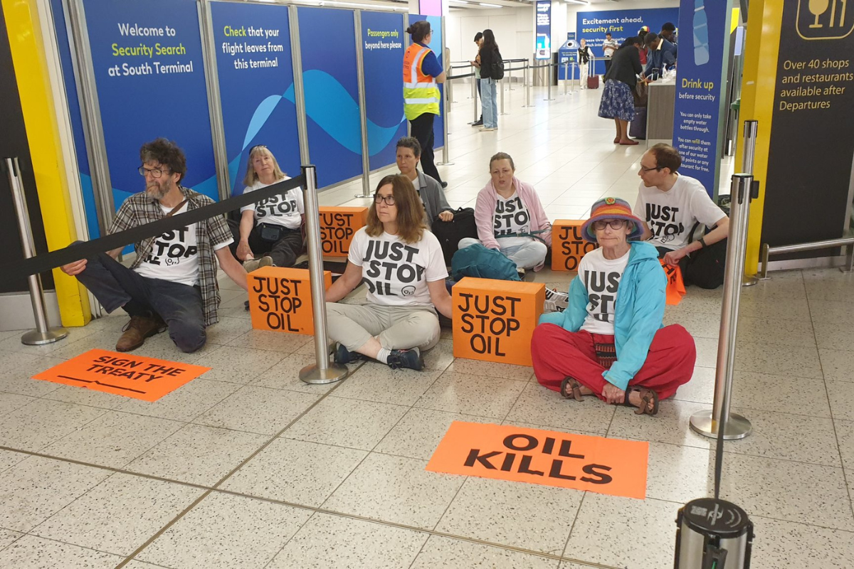 a group of people sitting on the floor with signs