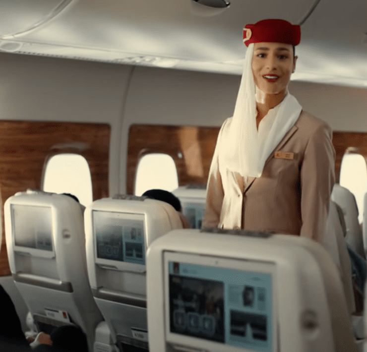 a woman in a red hat standing in an airplane
