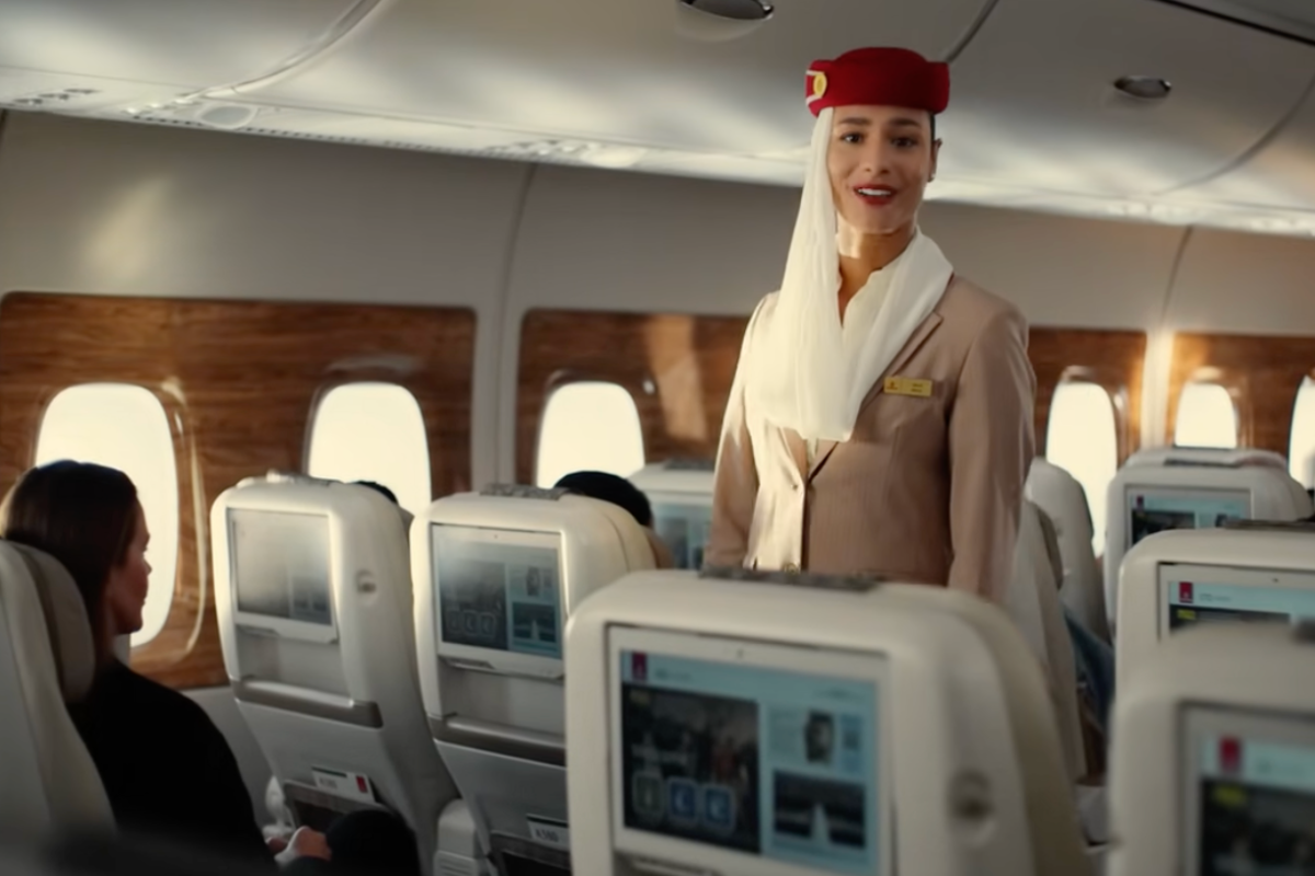 a woman in a red hat standing in an airplane