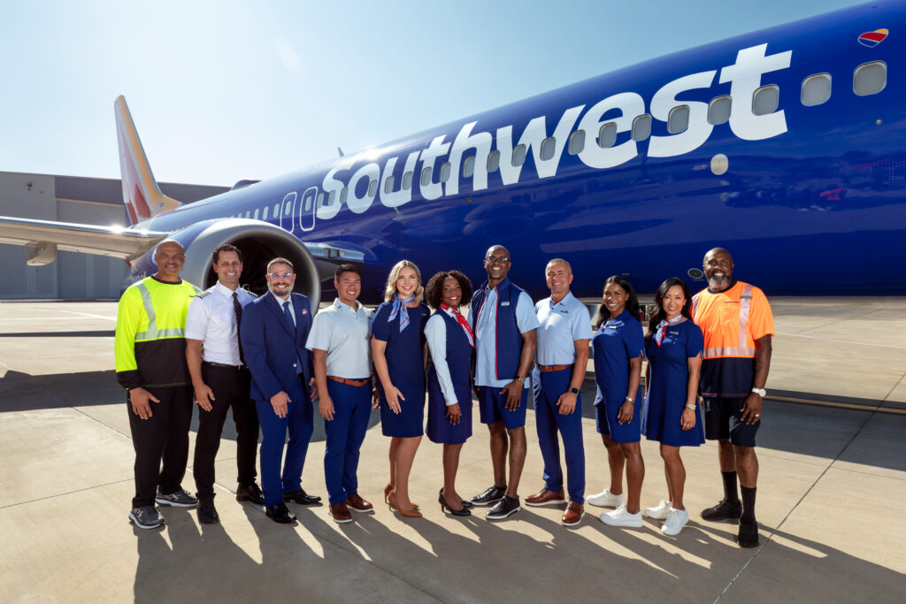 a group of people standing in front of a plane