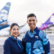 a man and woman standing in front of airplanes