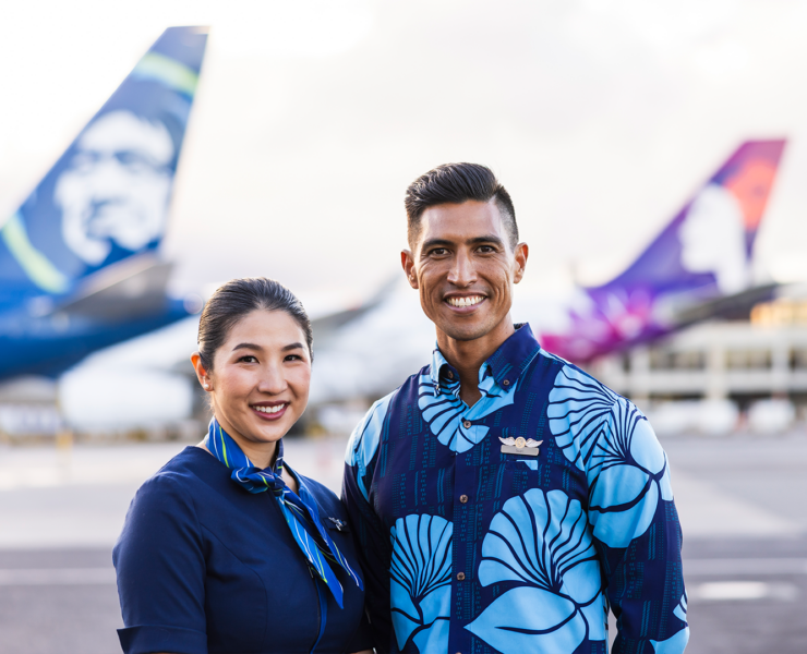 a man and woman standing in front of airplanes