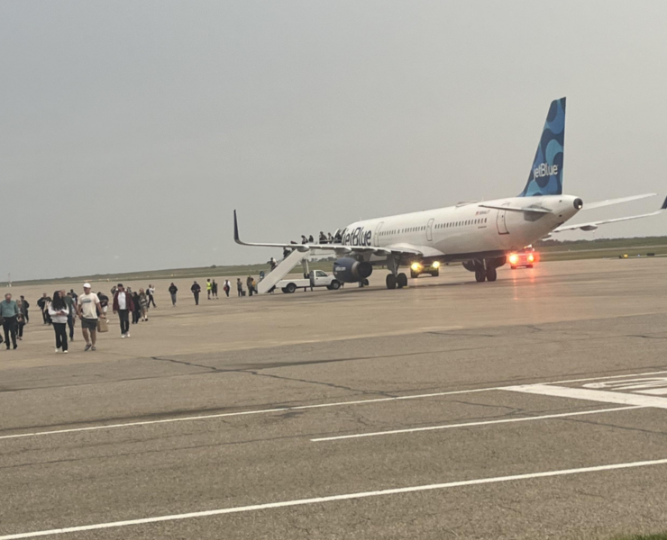 a group of people standing around an airplane