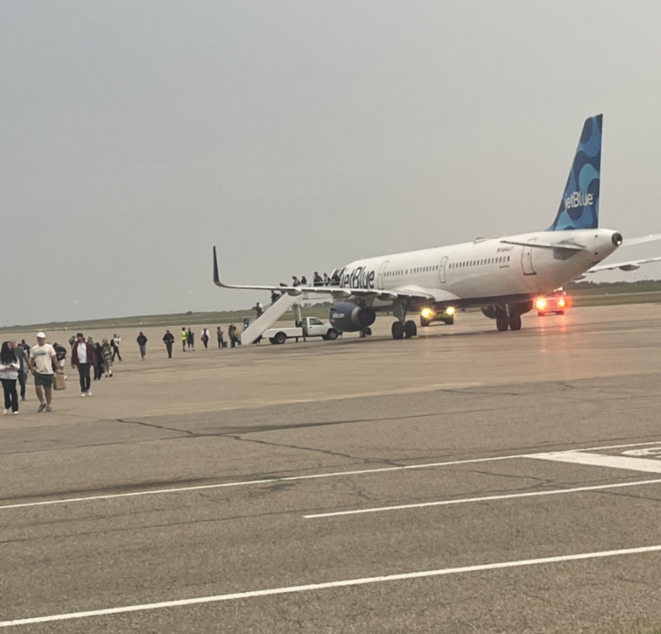 a group of people standing around an airplane