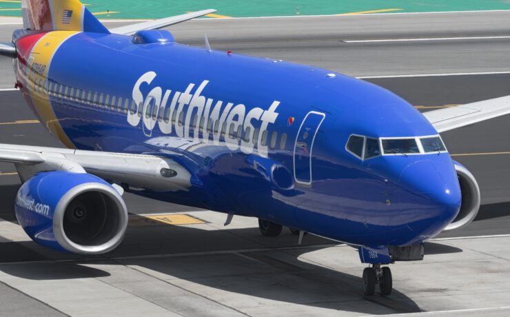 a blue airplane on a runway