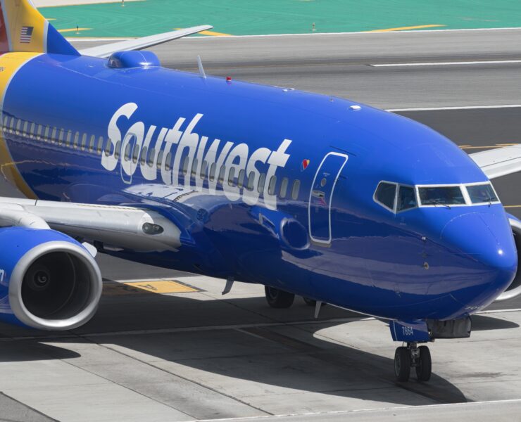 a blue airplane on a runway