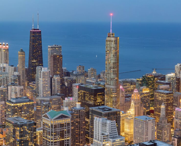 a city skyline with many tall buildings and a body of water