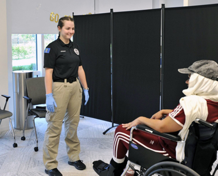 a woman standing next to a person in a wheelchair