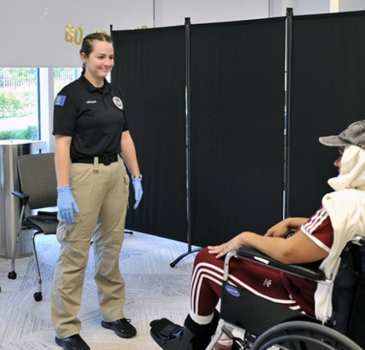 a woman standing next to a person in a wheelchair