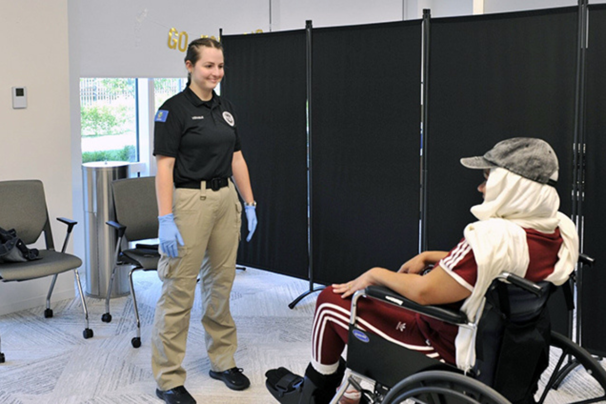 a woman standing next to a person in a wheelchair