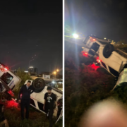 a group of people standing next to a car that crashed into a road