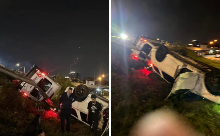 a group of people standing next to a car that crashed into a road