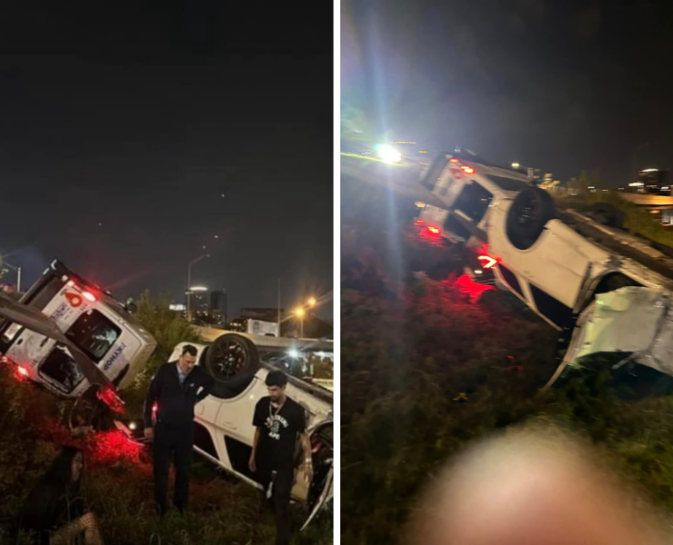 a group of people standing next to a car that crashed into a road