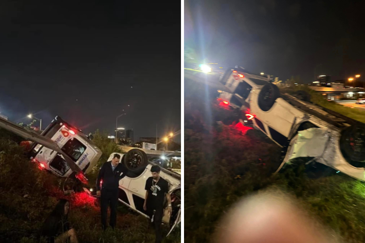 a group of people standing next to a car that crashed into a road