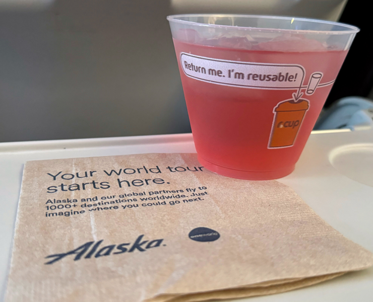 a cup of pink liquid on a napkin