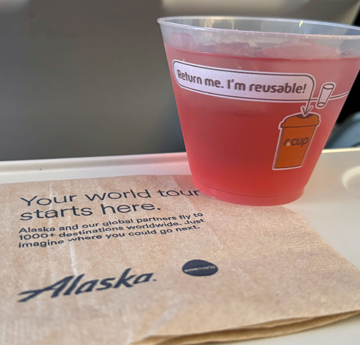 a cup of pink liquid on a napkin