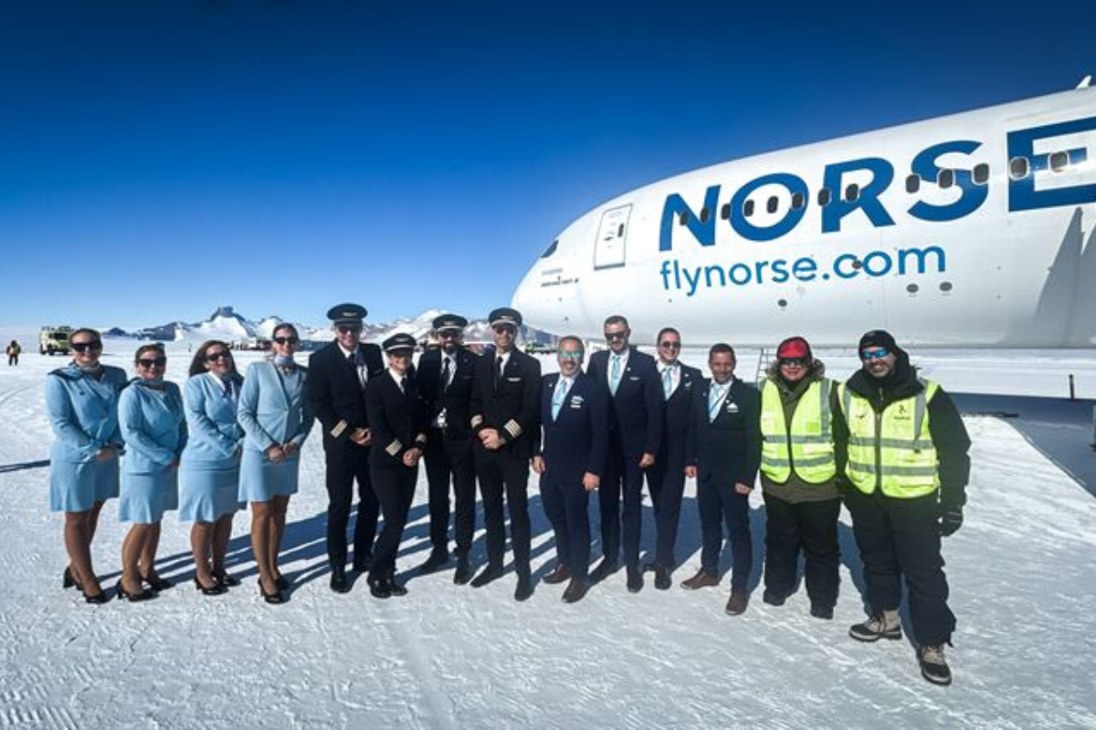 a group of people standing in front of a plane