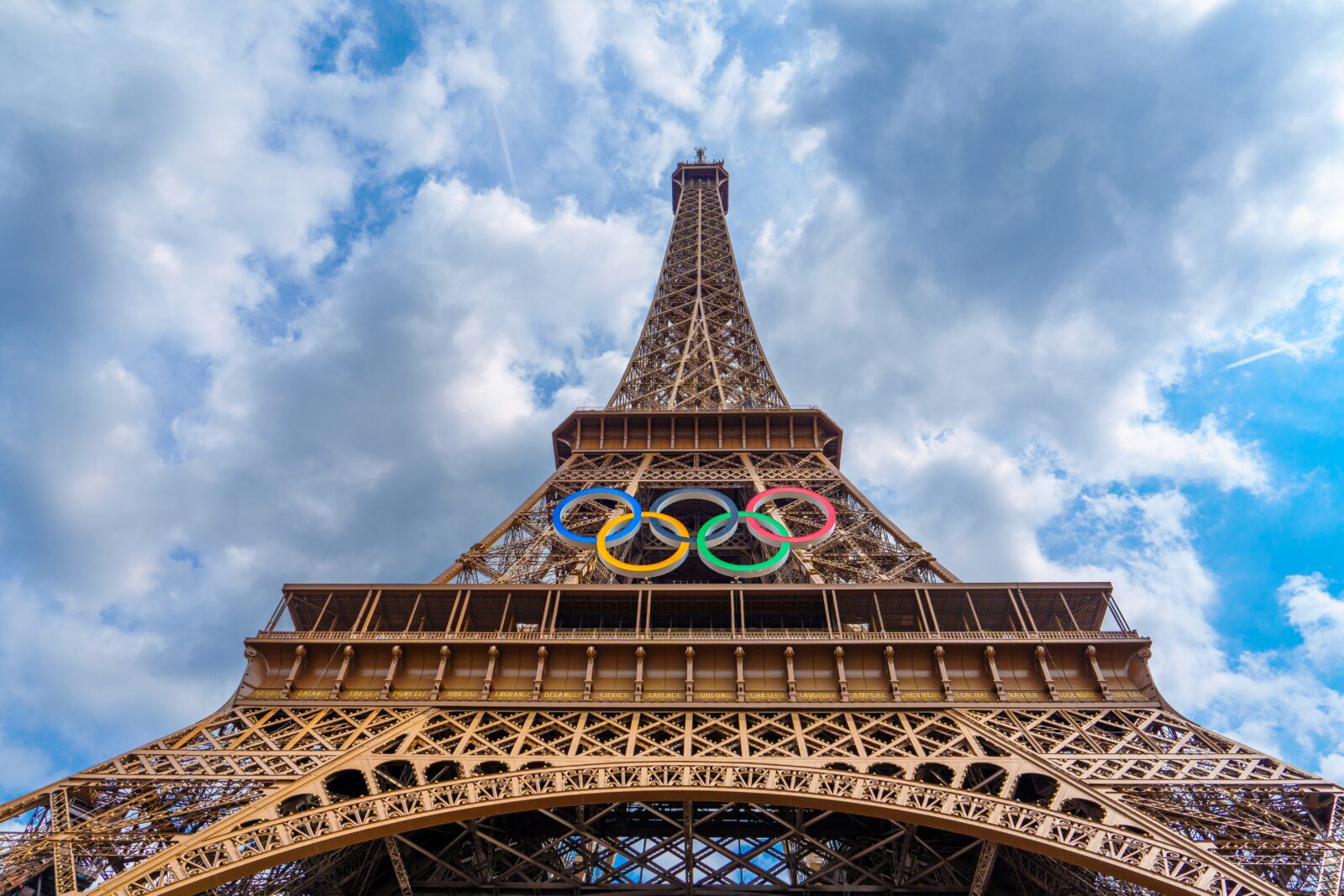 a tall metal tower with olympic rings on top