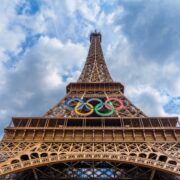 a tall metal tower with olympic rings on top